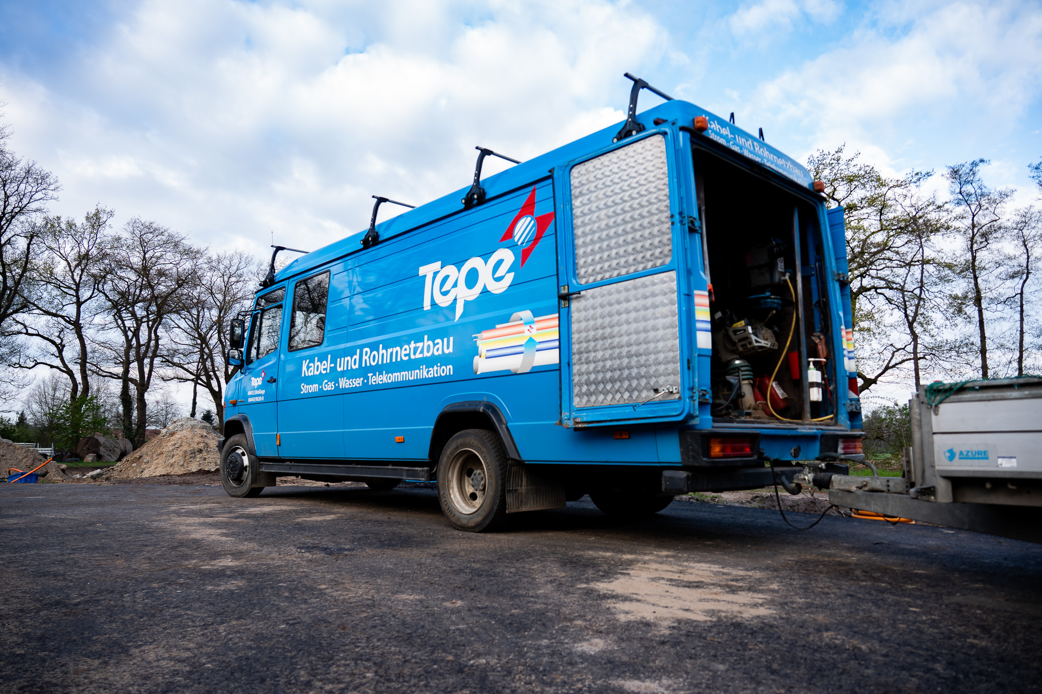 Blauer Tepe-Lkw für Kabel- und Rohrnetzbau auf einer Baustelle.