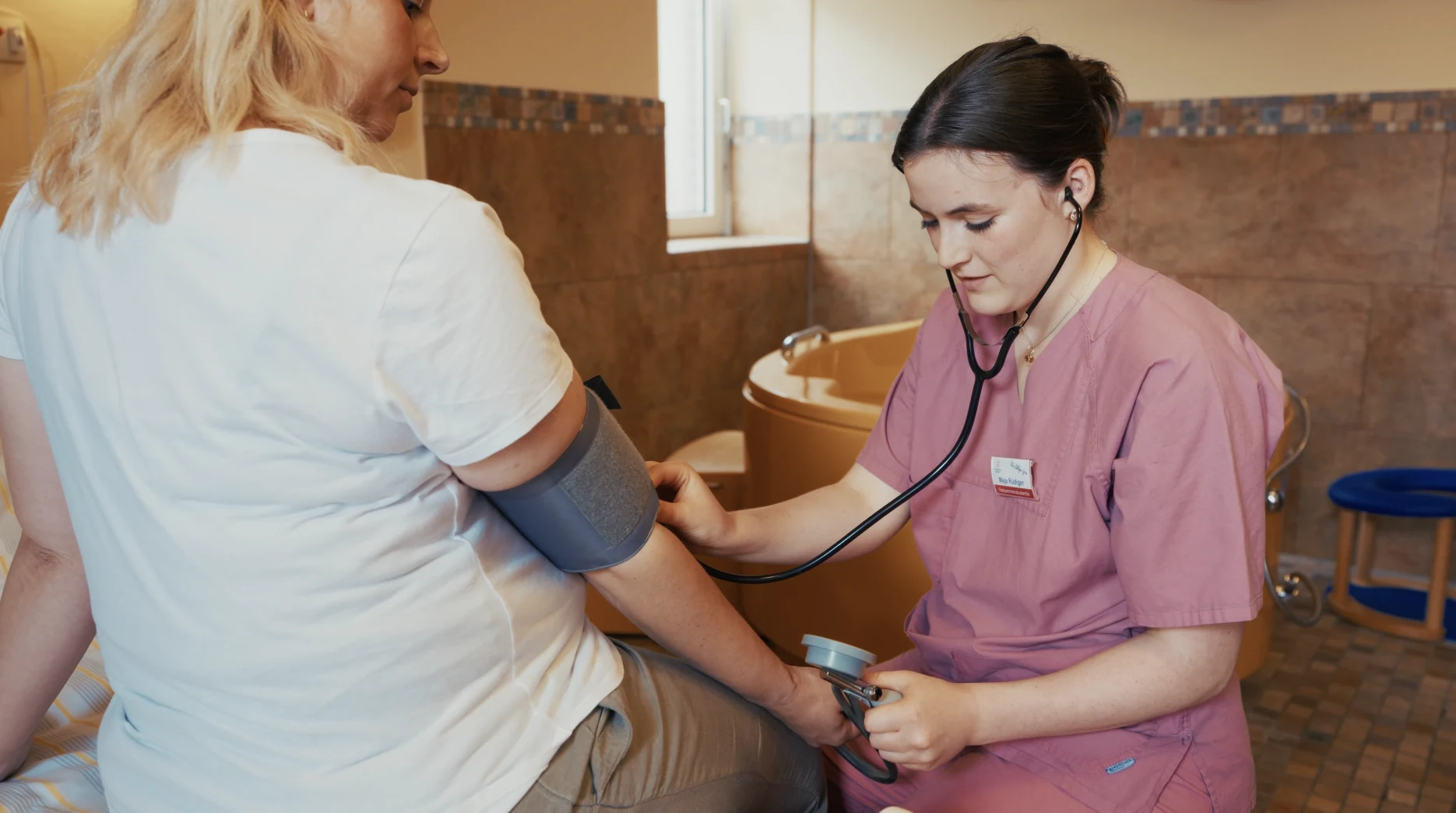 Hebammenstudentin Maja misst einer Patientin den Blutdruck