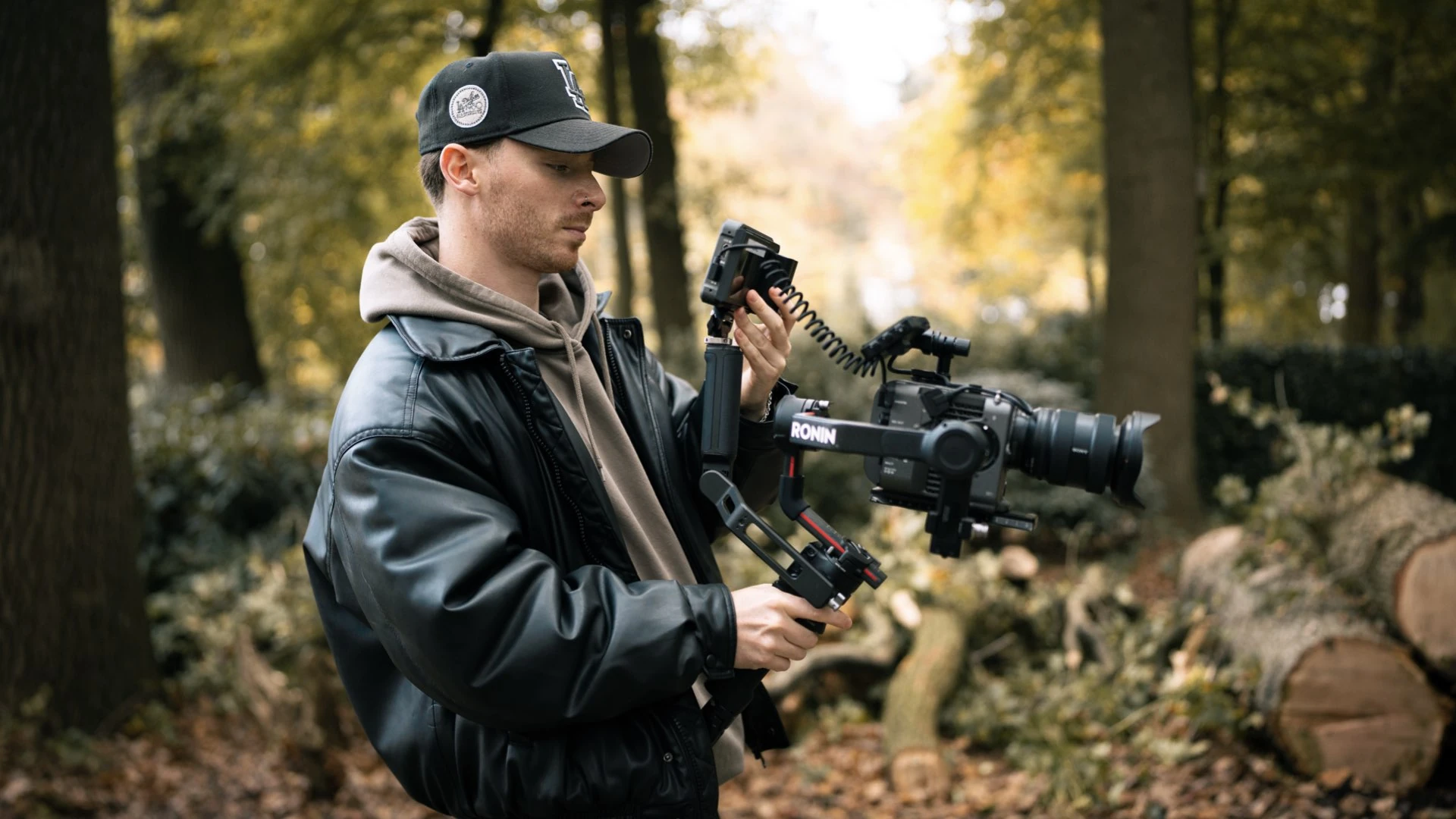 Kameramann mit Gimbal in einem herbstlichen Wald
